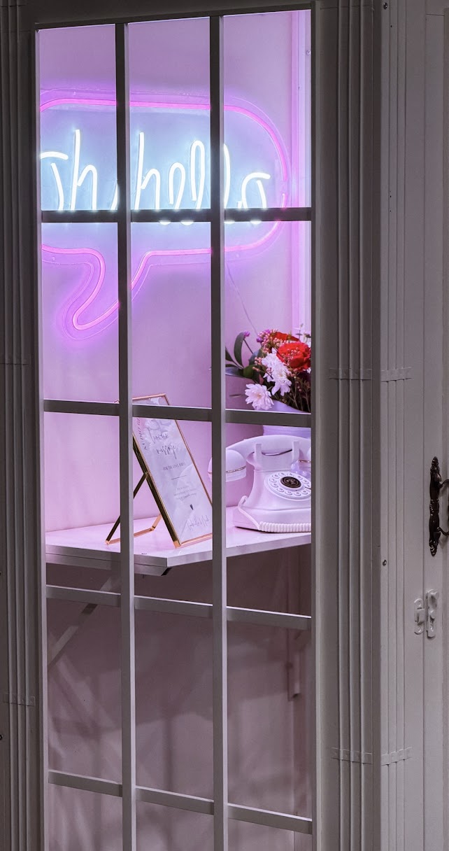 Close-up of styled photo booth with neon signage and guestbook