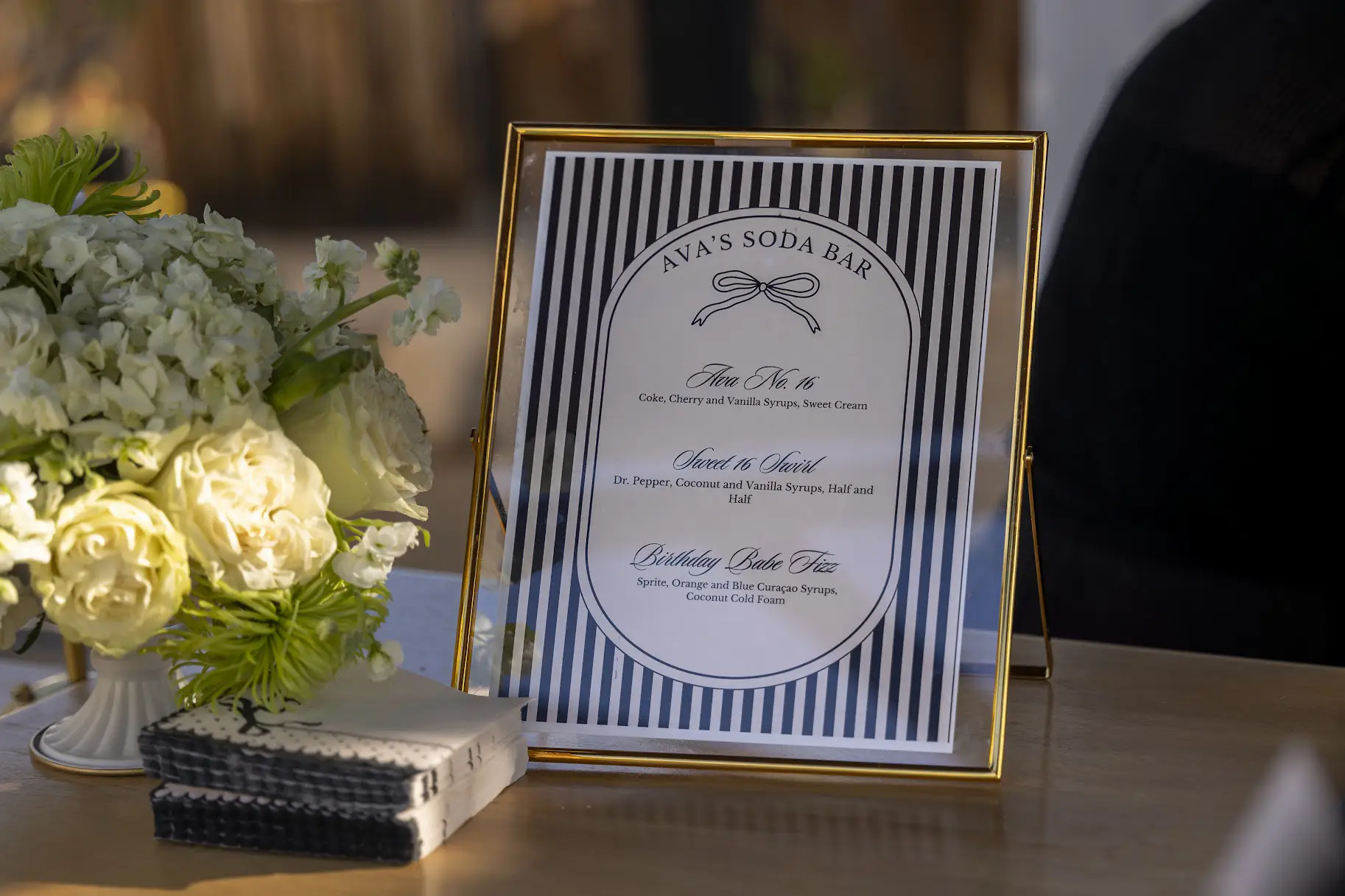 Styled mocktail bar with floral arrangement, custom drink menu, and signature pink drinks at an Inland Empire wedding