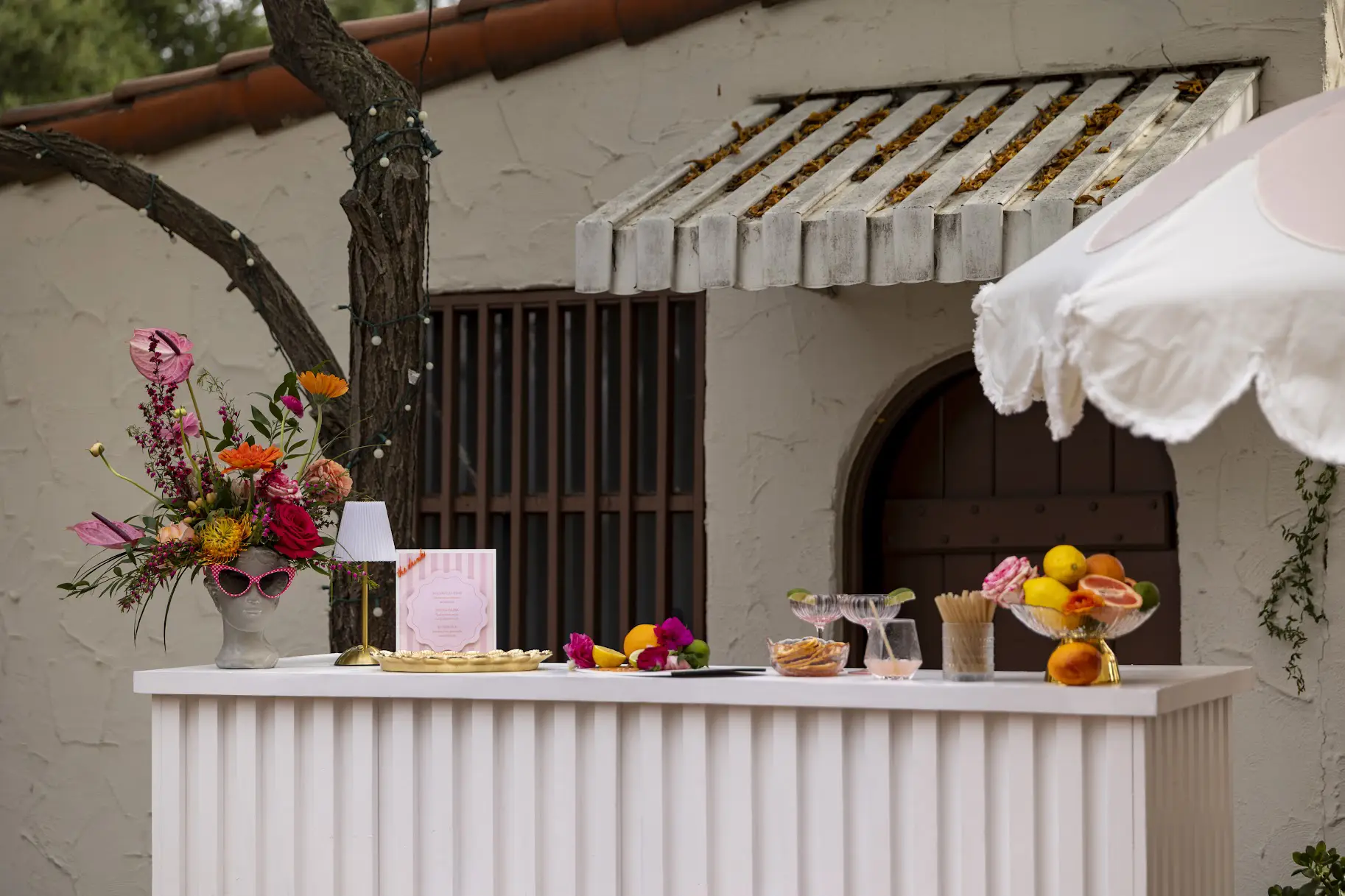 white fluted mobile bar styled with florals and citrus at an outdoor Spanish-style venue