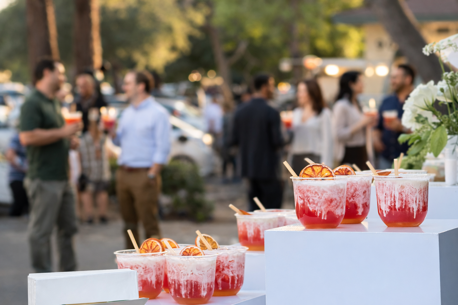 Guests gathering with pink dirty sodas at an outdoor social event